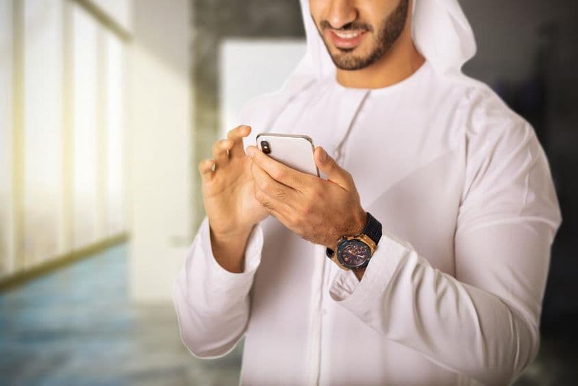 Homem árabe usando um telefone.