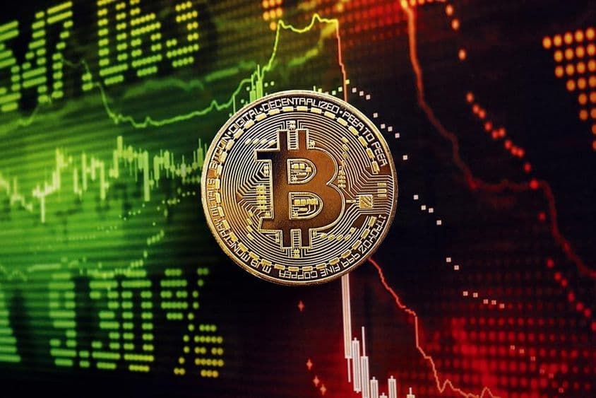 Moeda Bitcoin com um gráfico de mercado de ações ao fundo.
