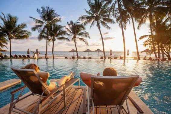 Maldivas, jovem casal tomando sol ao pôr do sol.