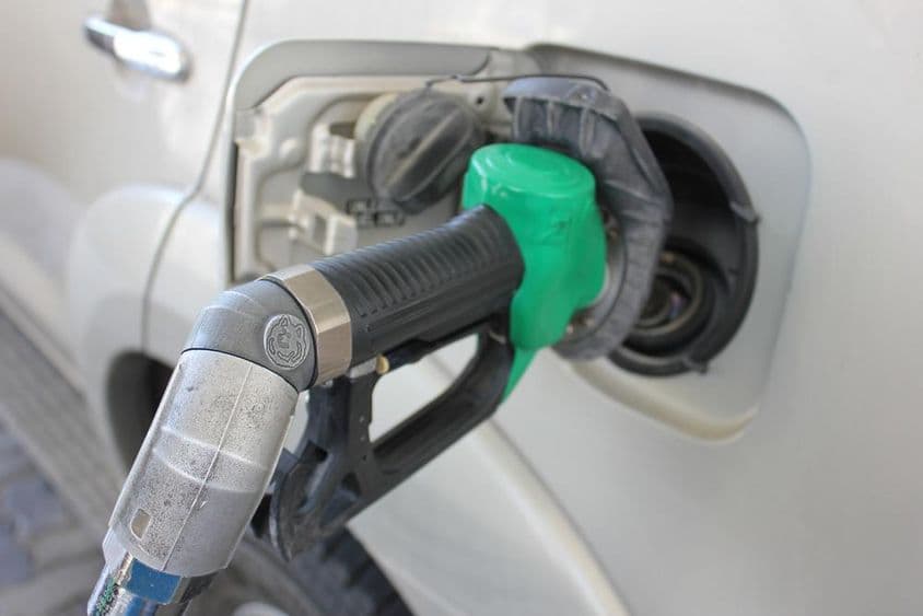 Abastecendo em um posto de gasolina um carro branco.