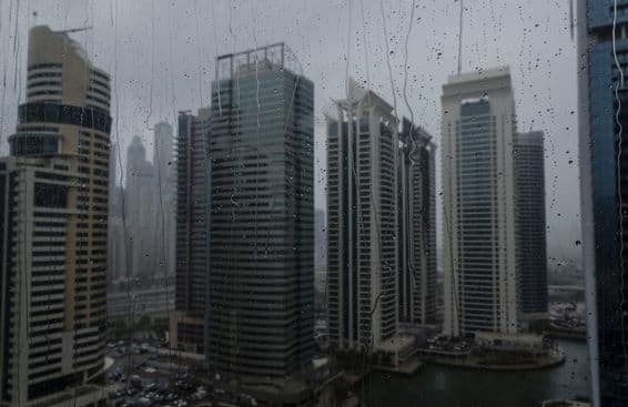 Dubai sob chuva, linha do horizonte vista através de vidro salpicado de chuva.