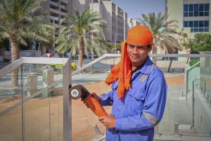 Trabalhador em Dubai polindo corrimão.