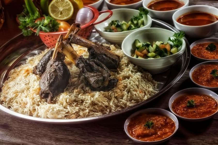 Perna de cordeiro com arroz, guarnições e sobremesa incluída.
