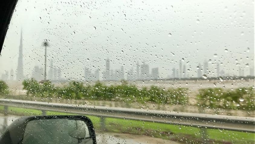 Gotas de chuva escorrendo pela janela de um carro.