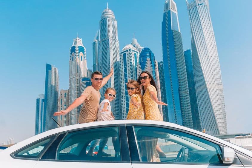 Férias em família com arranha-céus ao fundo.
