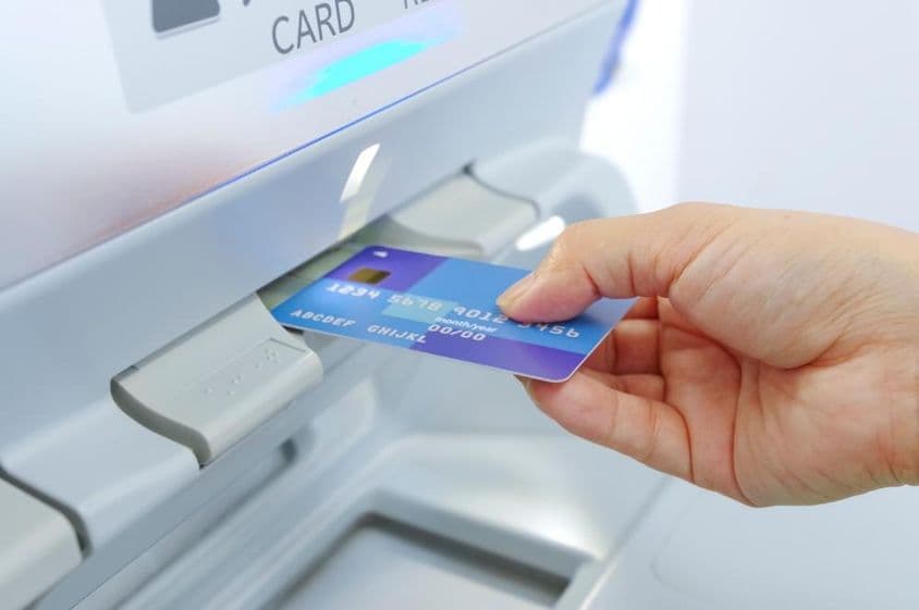Saque em caixa eletrônico com um cartão bancário.