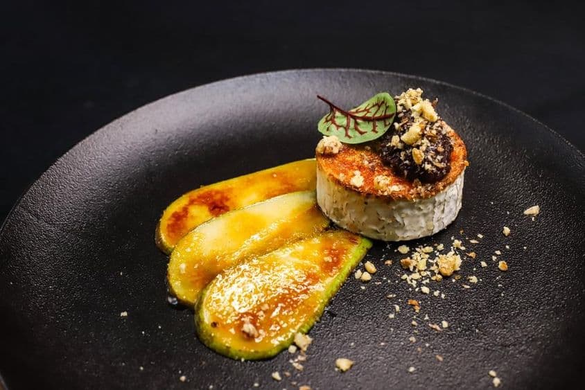 Queijo de cabra grelhado com pera caramelizada apresentado em estilo de alta gastronomia