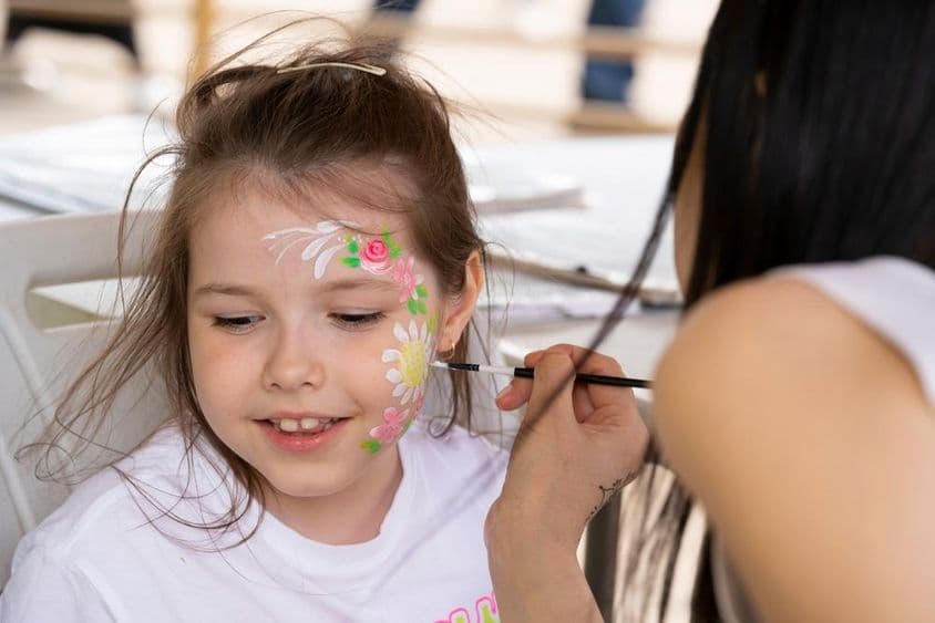 Pintura facial no rosto de uma jovem garota.