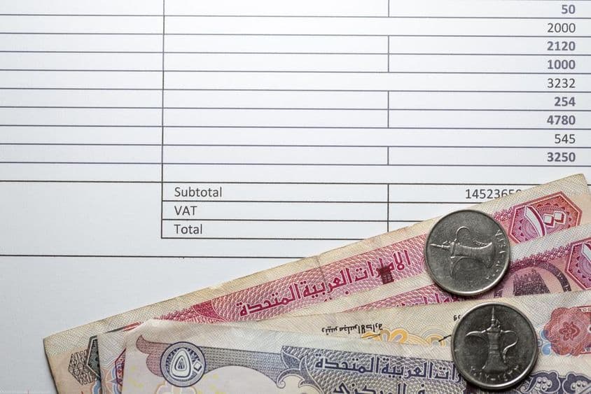 Notas de dirham, algumas moedas, contabilidade fiscal em um papel impresso.