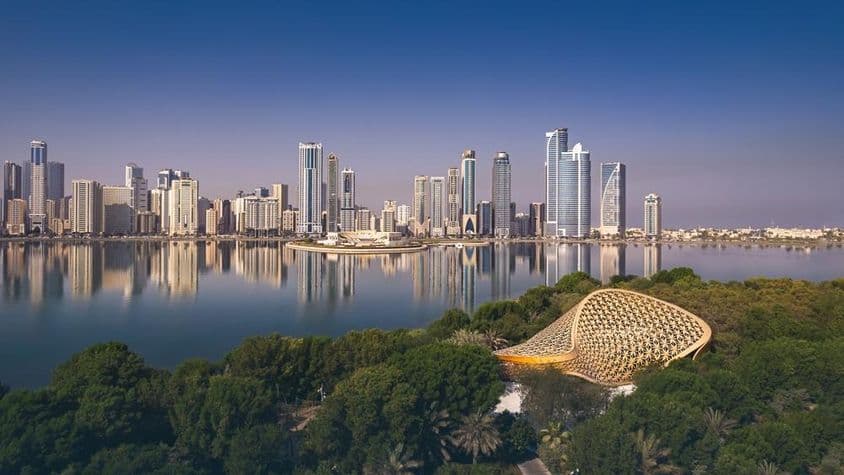 Imagem aérea de Sharjah mostrando a beleza de sua paisagem e horizonte urbano.