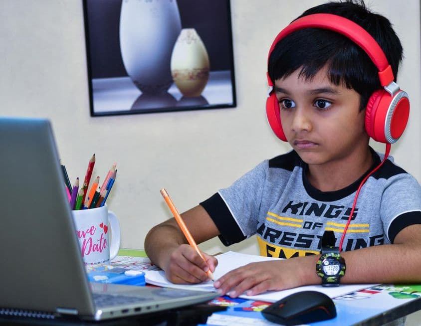 Criança de escola em Sharjah escrevendo uma lição.