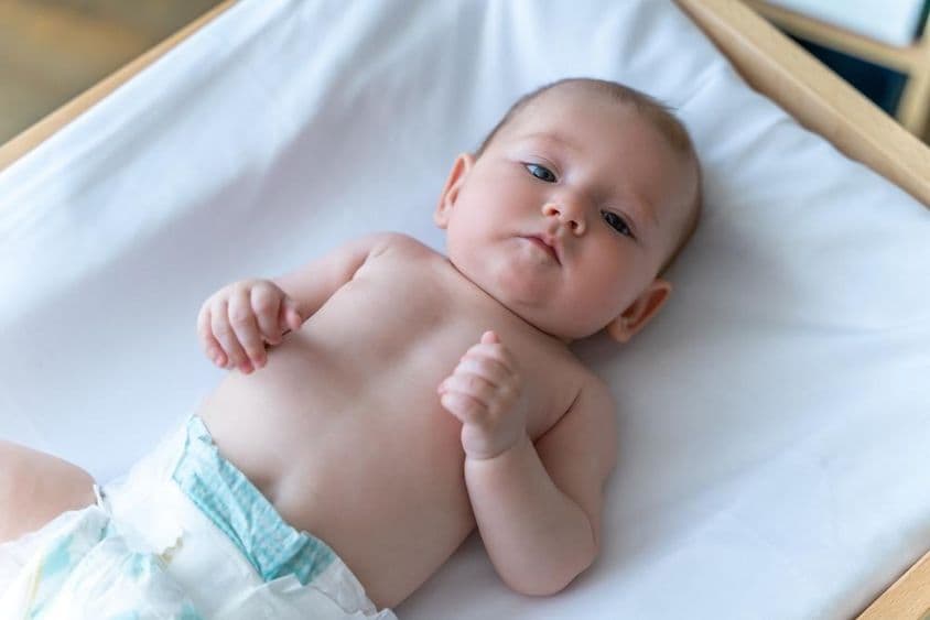 Bebê branco deitado de fralda.