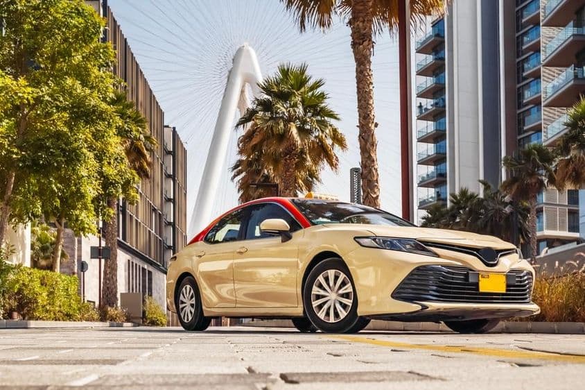 Táxi de Dubai com uma roda-gigante ao fundo.