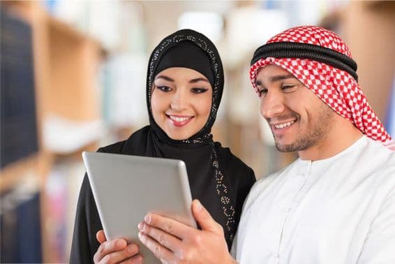 Alunos de árabe olhando material de estudo em um tablet.