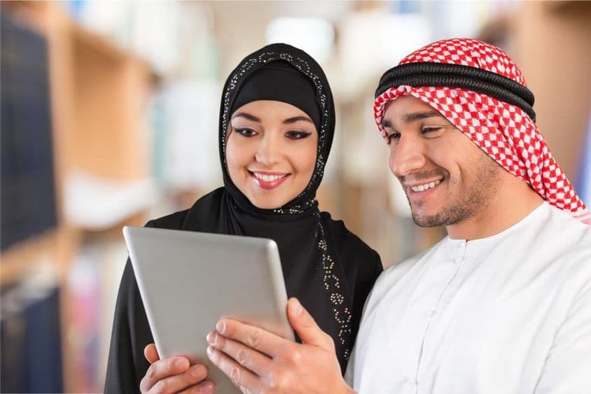 Alunos de árabe olhando material de estudo em um tablet.