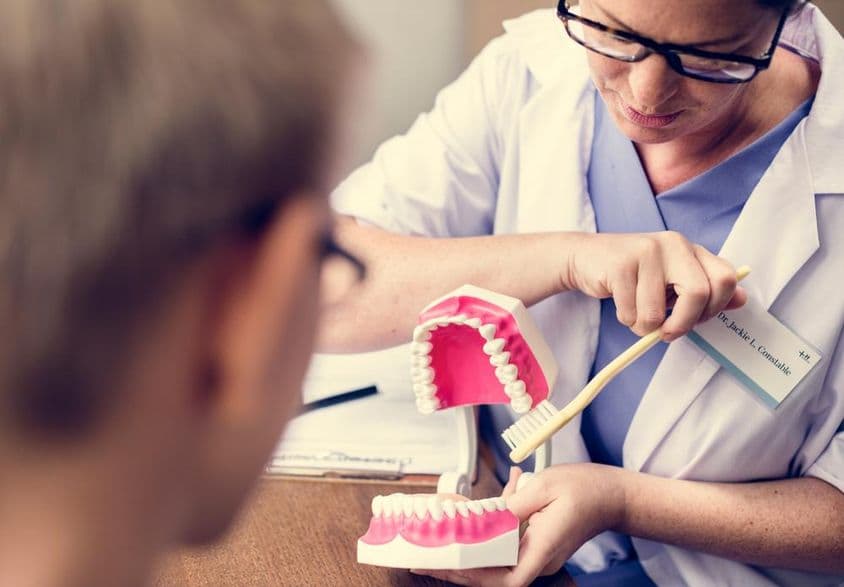 Dentista em Dubai demonstrando escovação de dentes.