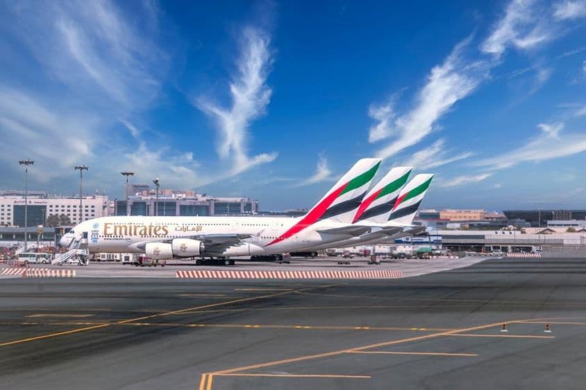 Aeroporto de Dubai com aviões da Emirates estacionados.