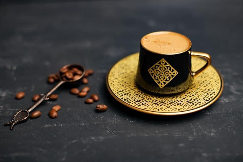 Xícara de café banhada a ouro e pires.