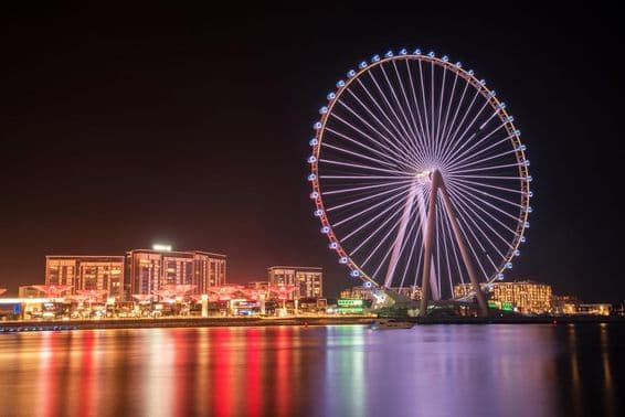 Roda-gigante Ain Dubai com prédios ao fundo.