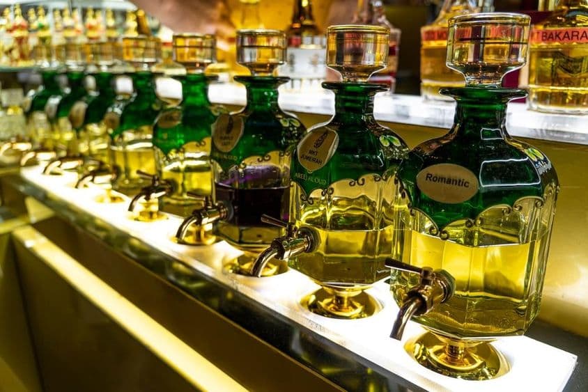 Close-up de frascos de óleos essenciais usados na perfumaria alinhados no mercado Souk Madinat Jumeirah.