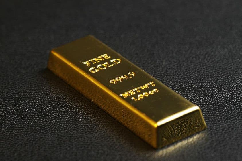 Barra de ouro 999,9 de pureza em fundo preto.