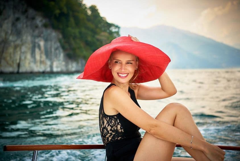 Modelo feminina fotografada em um barco a motor de madeira no Lago Como, Itália.