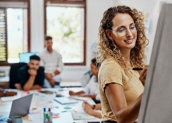 Reunião de coaching e apresentação com uma designer em um local de trabalho criativo para desenvolvimento de habilidades.