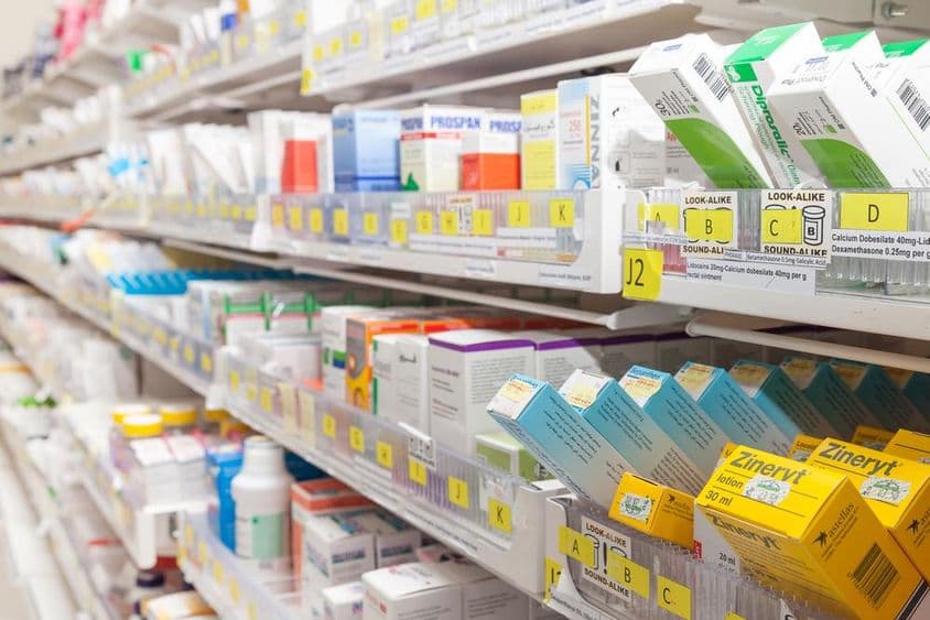 Prateleiras de farmácia com vários produtos.