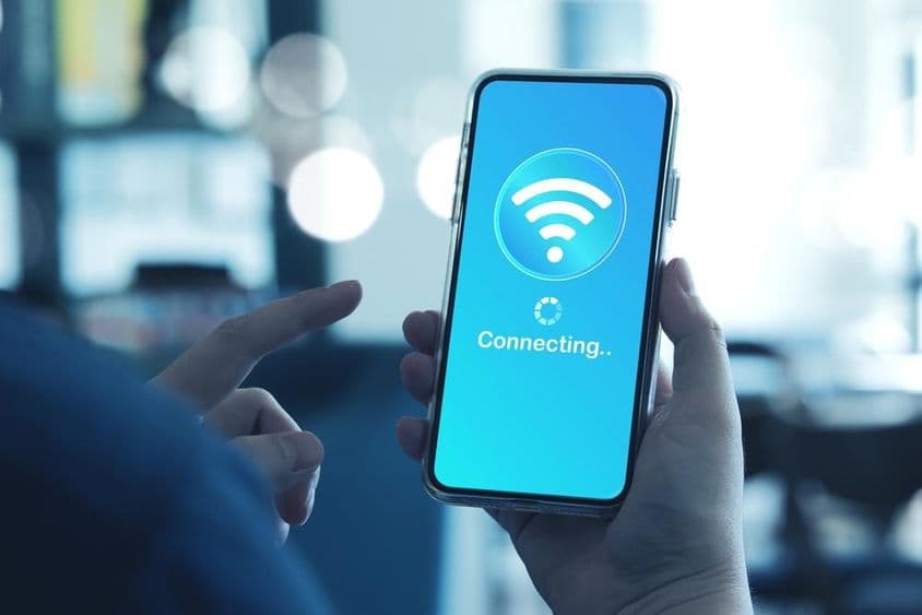 Homem usando smartphone para se conectar ao Wi-Fi no celular.