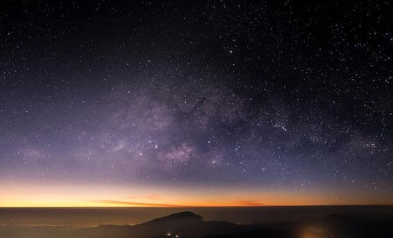 Altas montanhas, noite, Via Láctea e estrelas no céu noturno são lindas.