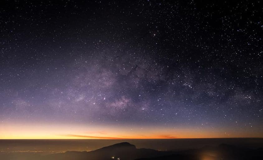 Altas montanhas, noite, Via Láctea e estrelas no céu noturno são lindas.