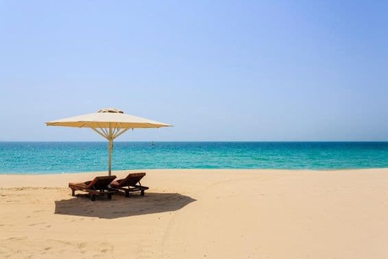Espreguiçadeiras na areia da Praia Jumeirah, Dubai.