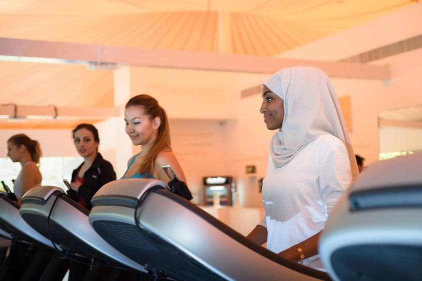 Grupo de mulheres usando a esteira na academia.