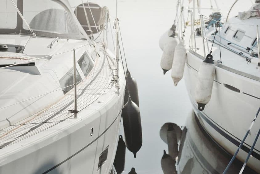 Veleiro moderno e branco atracado em uma marina.