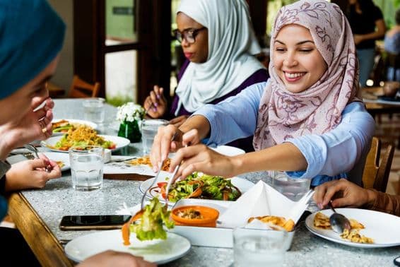Mulheres muçulmanas jantando com hijabs.