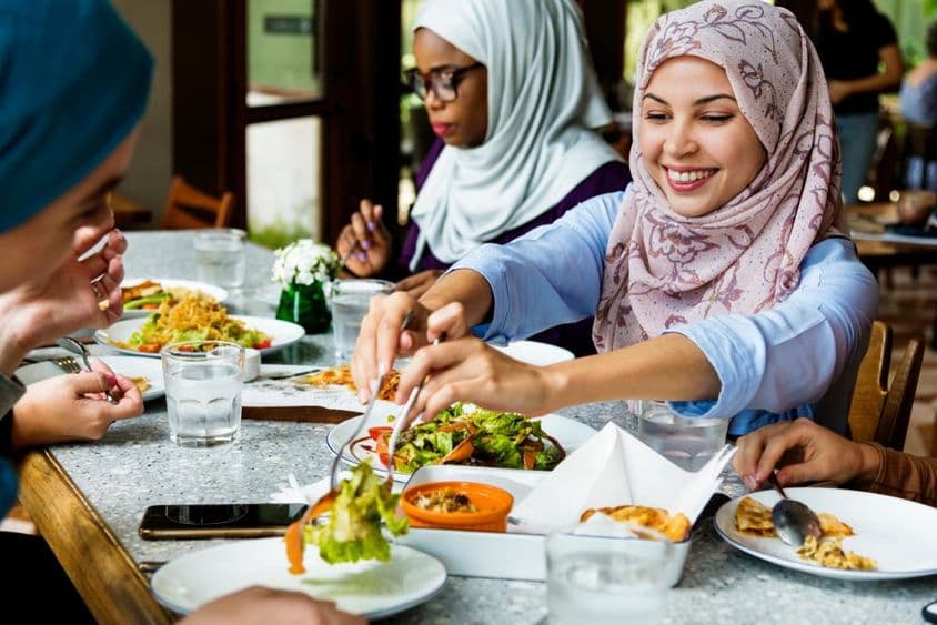 Mulheres muçulmanas jantando com hijabs.
