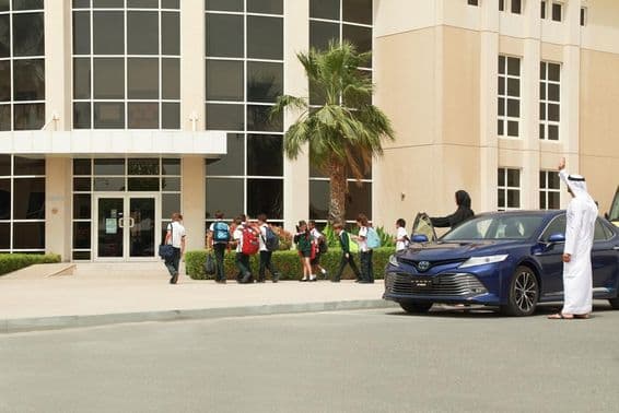 Um casal árabe levando seus filhos para a escola.