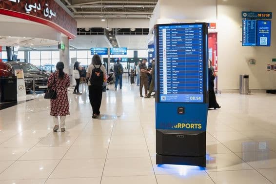 Interior do aeroporto de Dubai com um painel de informações.