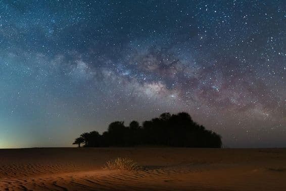 Estrelas noturnas enchem o céu leitoso sobre o deserto Oasis.