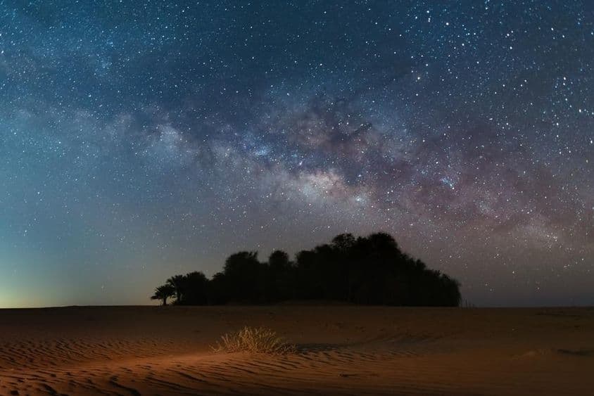 Estrelas noturnas enchem o céu leitoso sobre o deserto Oasis.