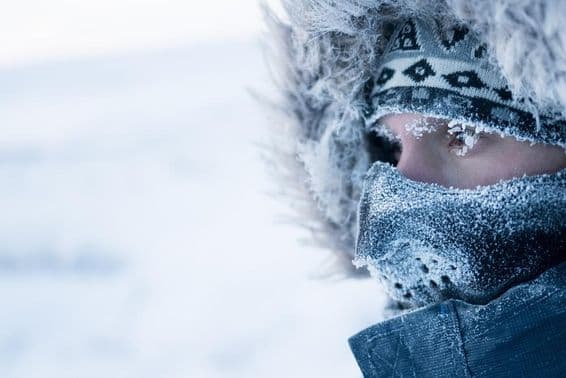 Um homem com roupa de inverno e máscara, clima ártico frio
