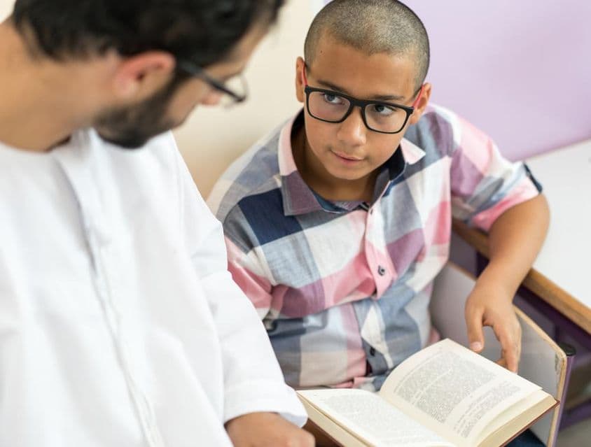 Professora árabe jovem estudando com um aluno.