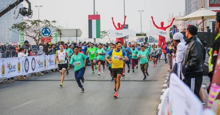 Corredores e vencedores da maratona no percurso de rua.