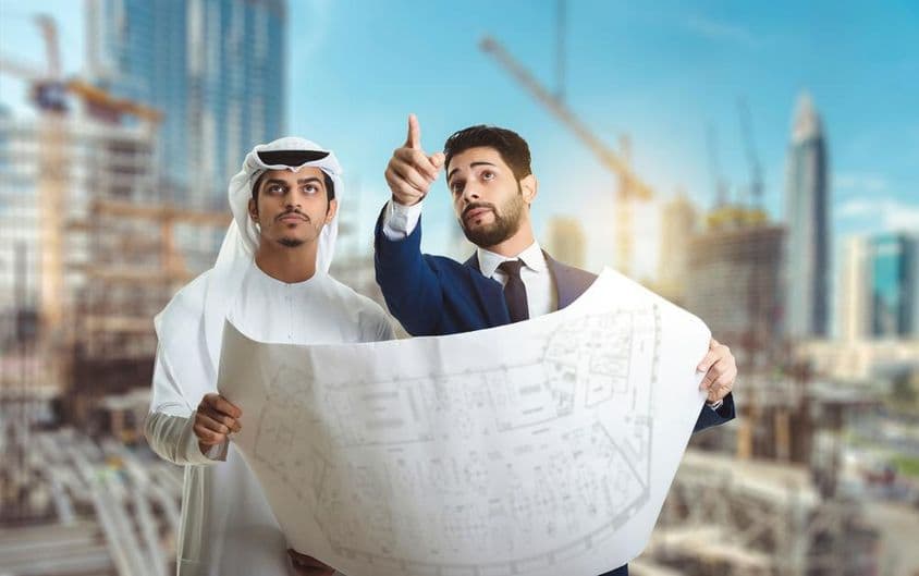 Arquiteto explicando o plano de construção para construtores árabes