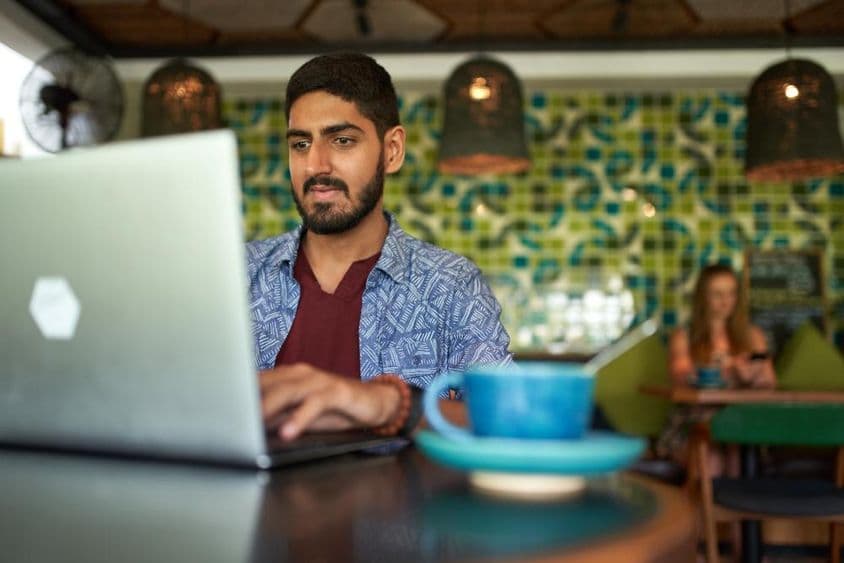 Homem indiano trabalhando em um espaço de coworking moderno.