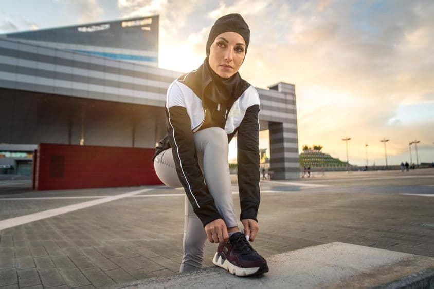 Mulher muçulmana fazendo exercício de corrida na cidade no centro.