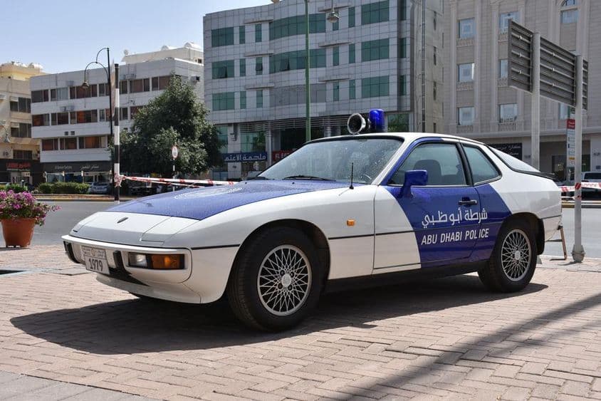 Exibição de carros clássicos da polícia de Abu Dhabi, carro patrulha azul e branco.