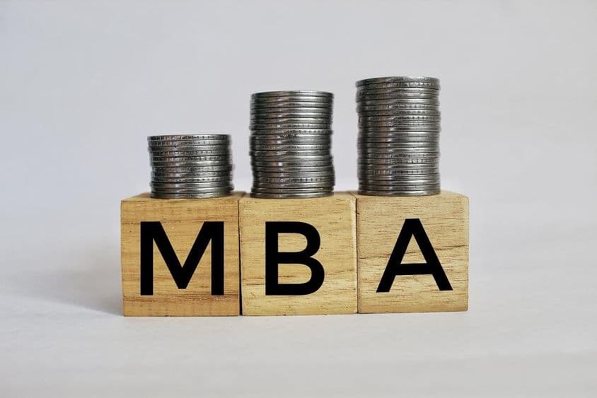 MBA Administração de Empresas escrito em cubos empilhados em moedas.