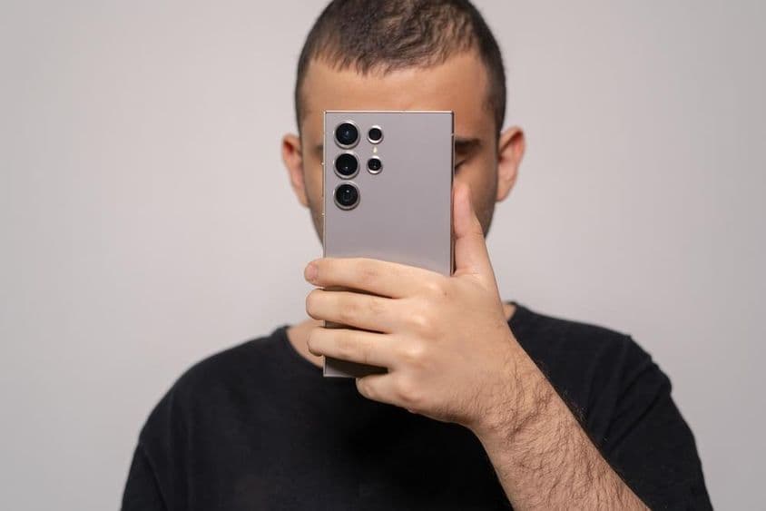 Homem segurando o smartphone Samsung S24 Ultra, destacando o design elegante.