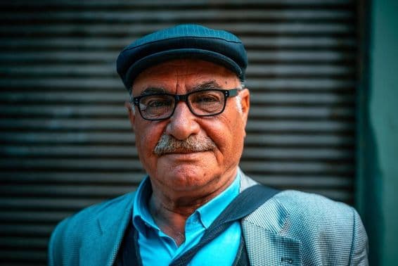 Homem mais velho usando um chapéu na rua.